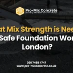 Pro-Mix Concrete logo and branding. The text reads: "What Mix Strength is Needed for Safe Foundation Work in London?" Below the main text is a contact number "020 7458 4747" and website "www.pro-mixconcrete.co.uk". The background is a dark, blurry image of wet concrete being poured from a chute onto a surface.